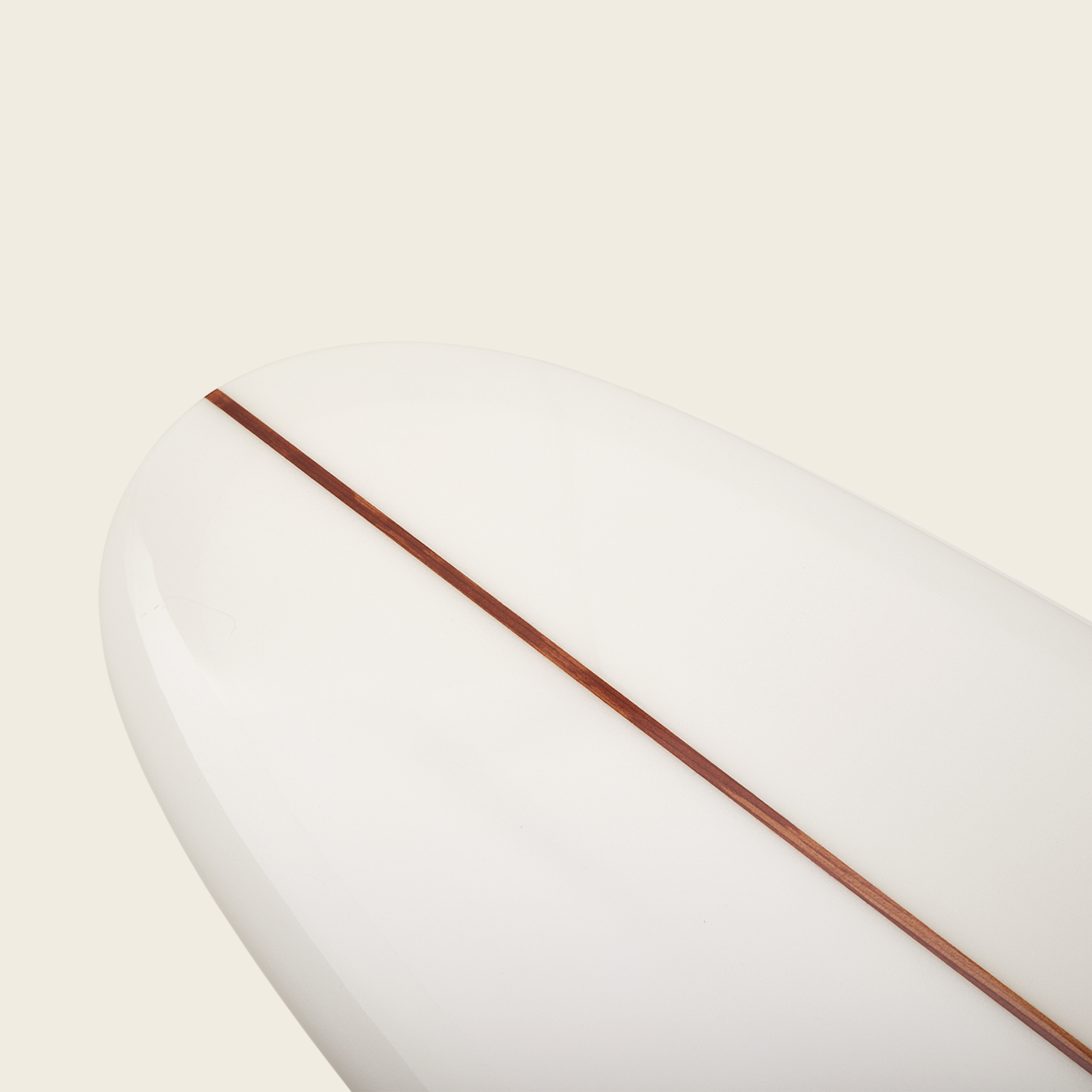 A close-up of a white longboard surfboard’s nose, featuring a single brown wooden stringer running down the center, highlighting the Surf Thumps versatile handling against a plain light background. - View 4