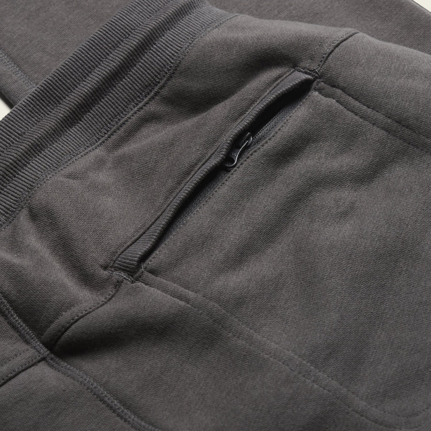 Close-up of Mellow Mono Sweatpants in dark gray, highlighting the drawstring waistband and a zippered pocket detail. The French terry fabric appears soft and slightly textured. - View 5