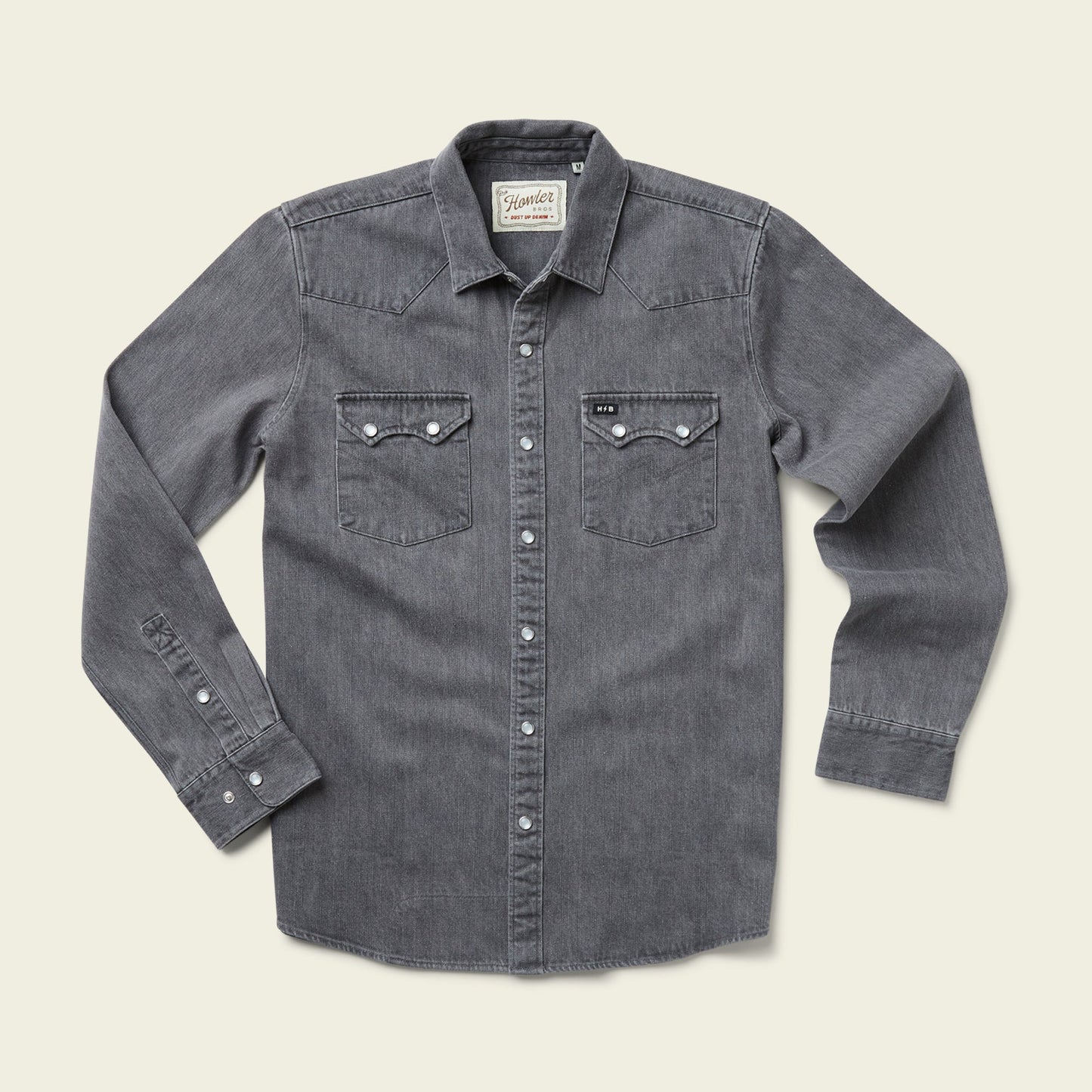 A long-sleeve, button-up gray Denim Snapshirt with two front chest pockets and white buttons, laid flat on a light beige background—perfect for those seeking versatile style. - View 4