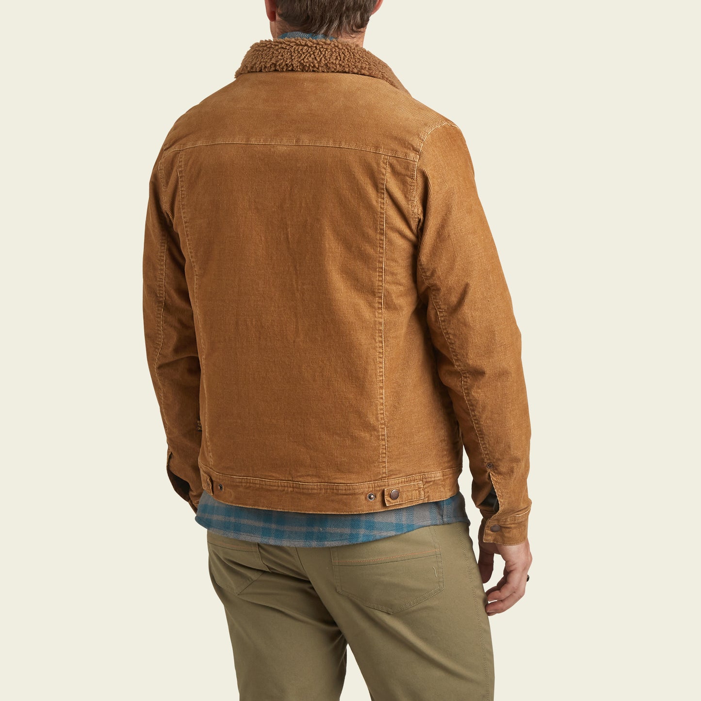 A person wearing the Fuzzy Depot Jacket—a light brown corduroy jacket with a sherpa lining—khaki pants, and a blue plaid shirt stands facing away from the camera against a light background. - View 5