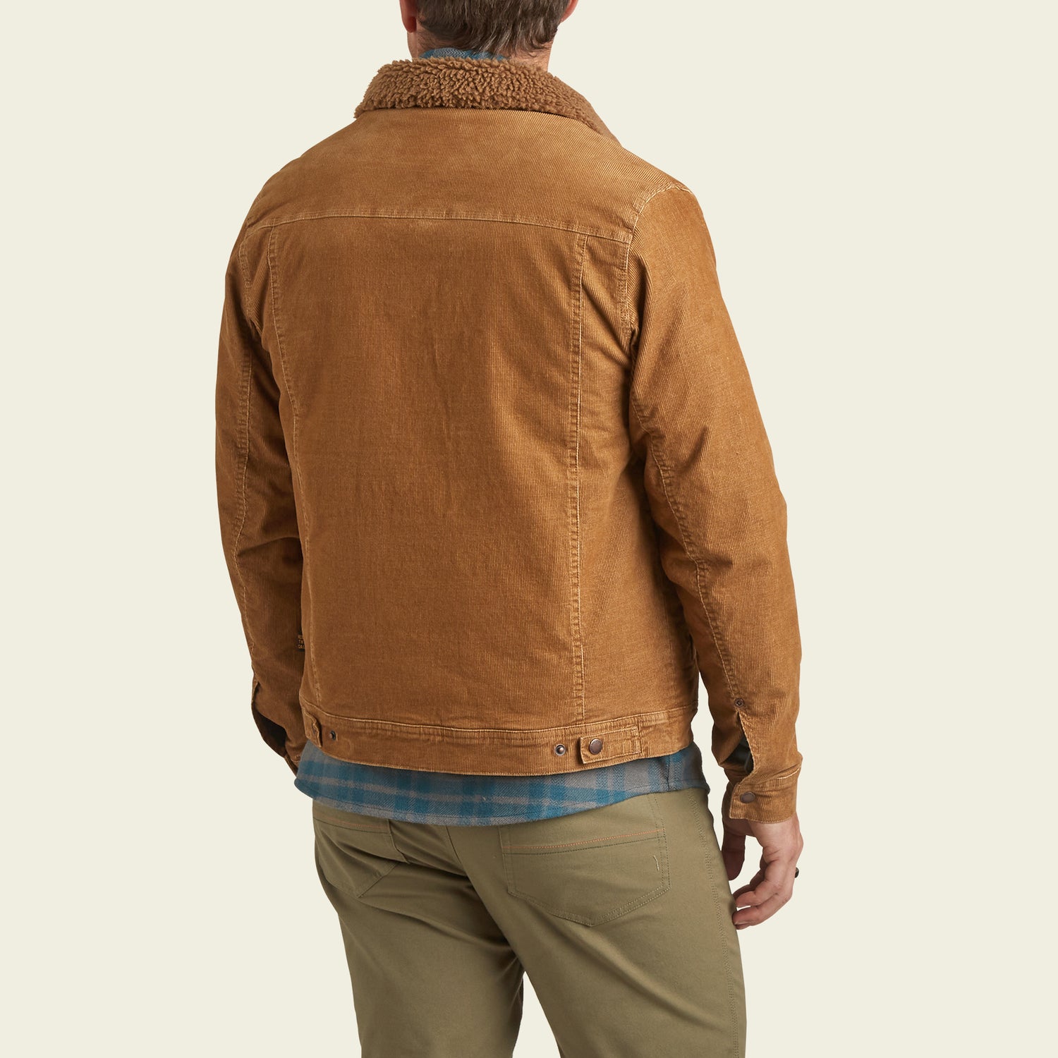 A person wearing the Fuzzy Depot Jacket—a light brown corduroy jacket with a sherpa lining—khaki pants, and a blue plaid shirt stands facing away from the camera against a light background. - View 5