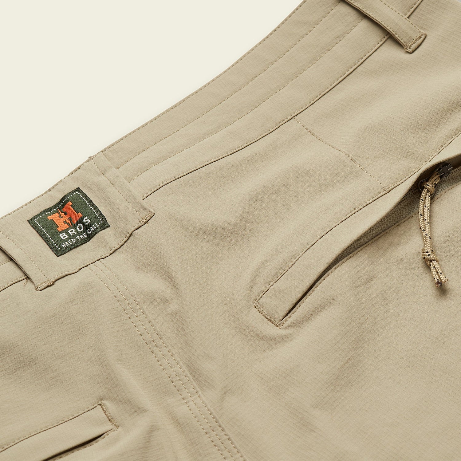 Close-up of beige stretch nylon pants showing a front pocket, belt loops, a drawstring tie, and a green tag with H BROS and PRESTO CHINO printed on it. - View 6