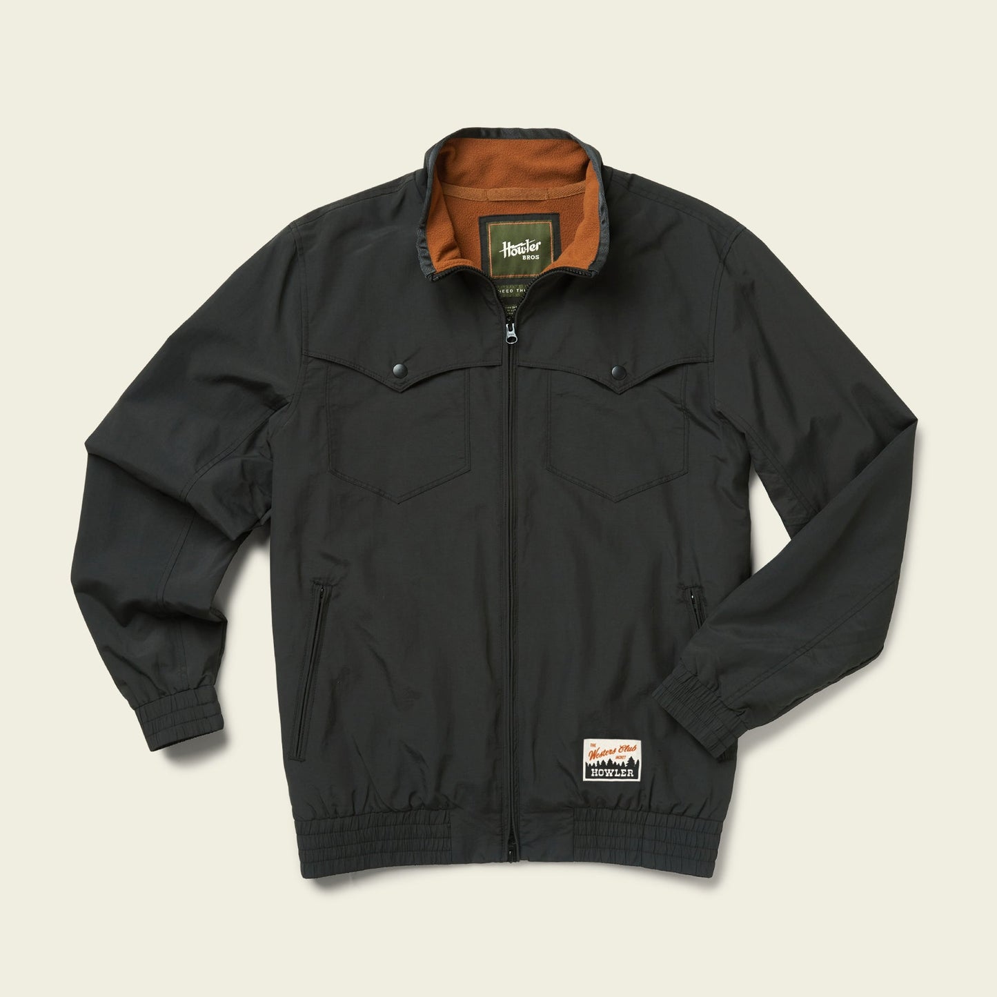 A black zip-up vintage jacket with chest pockets, front hand pockets, an elastic waistband and cuffs. The inside collar is brown, and there is a small stitched label near the hem. The jacket is laid flat on a light background. - View 3