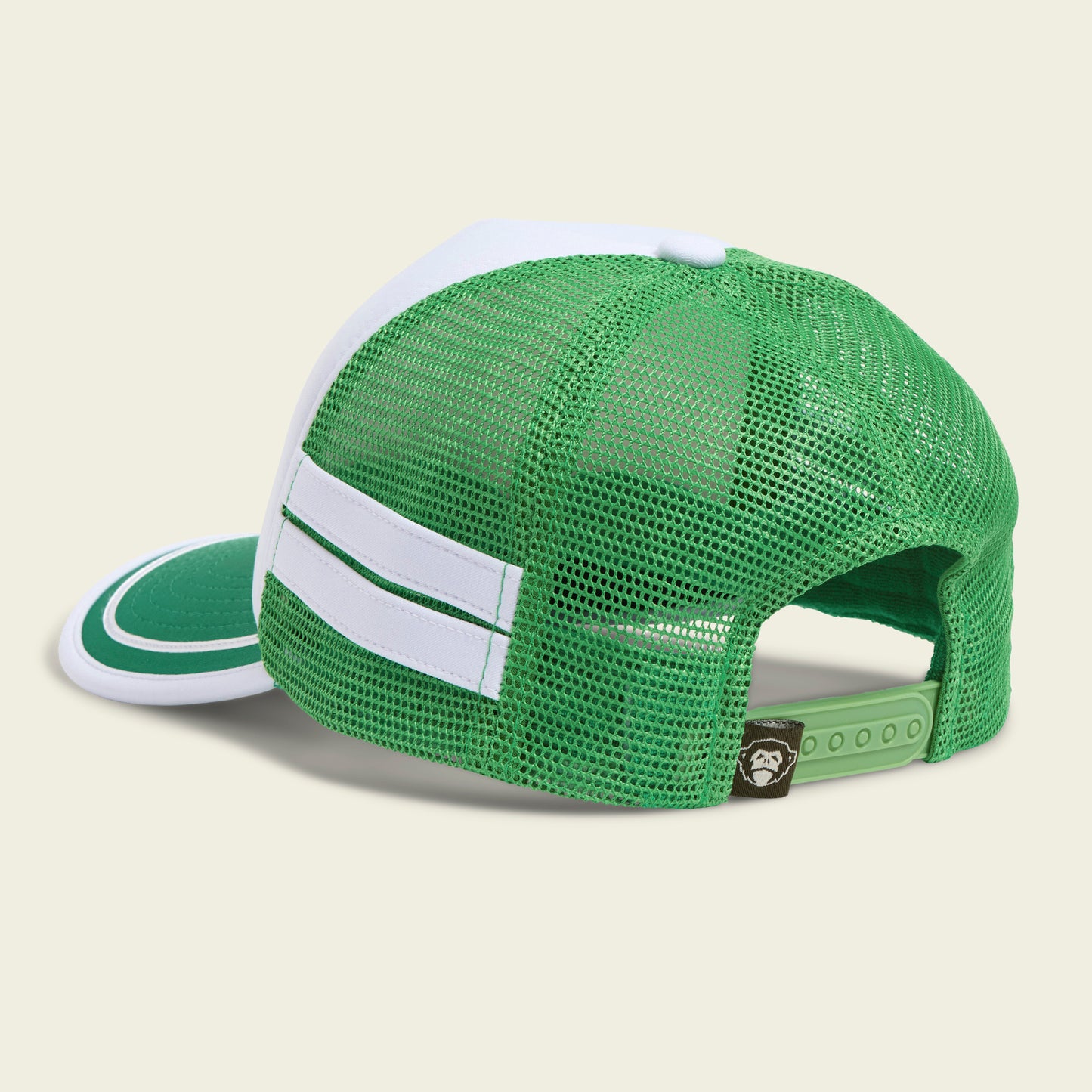 A vintage-inspired hat, this green and white mesh trucker features two white stripes on the side, a curved brim, and an adjustable snapback closure. The back includes a small brown tag with a white graphic. - View 3