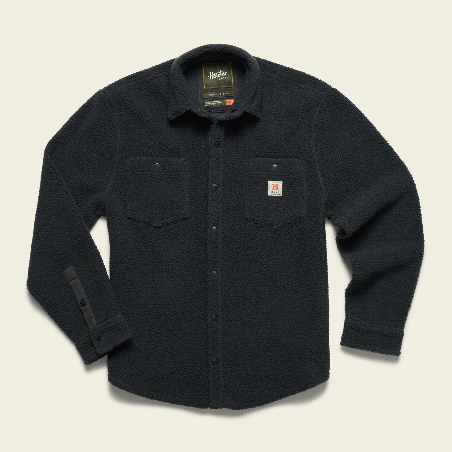 A black, long-sleeve fleece overshirt with a button front, two chest pockets with flaps, and a small Carhartt logo patch on the left pocket, made from high pile fleece and laid flat on a light background. - View 3