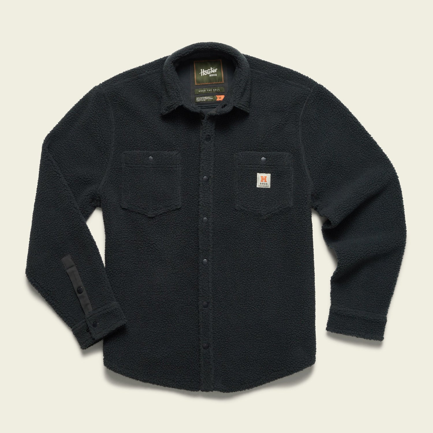 A black, long-sleeve fleece overshirt with a button front, two chest pockets with flaps, and a small Carhartt logo patch on the left pocket, made from high pile fleece and laid flat on a light background. - View 4