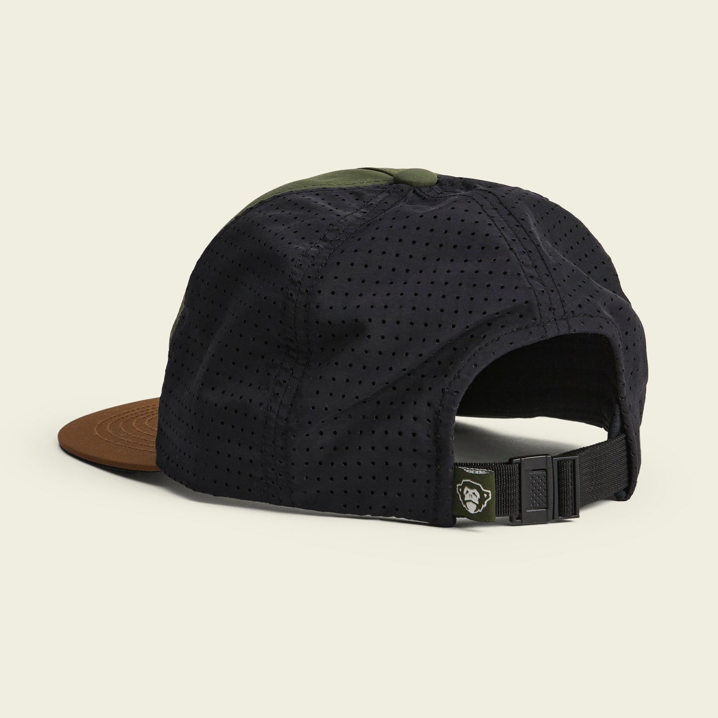 A black perforated breathable tech hat with a brown brim, green top button, and an adjustable strap at the back, perfect for outdoor adventures. Shown on a plain light background. - View 3