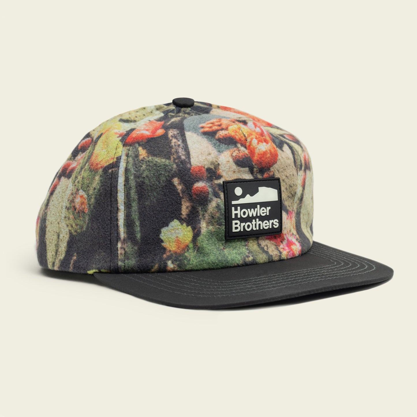 A five-panel cap featuring a colorful nature-inspired pattern, a pliable brim, an adjustable snapback closure, and a rectangular Howler Brothers logo patch on the front. - View 1