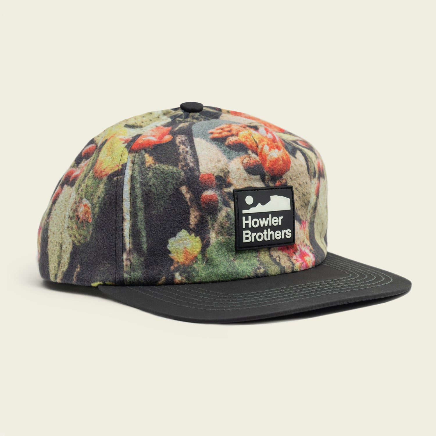 A five-panel cap featuring a colorful nature-inspired pattern, a pliable brim, an adjustable snapback closure, and a rectangular Howler Brothers logo patch on the front. - View 1