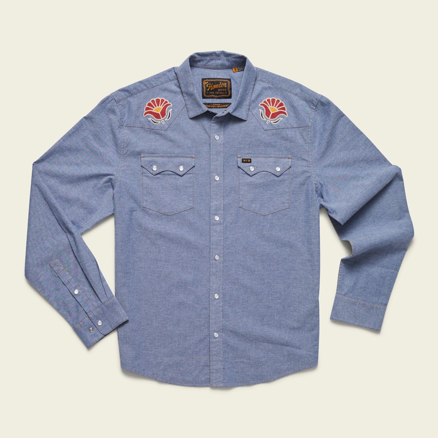 Light blue long-sleeve button-up shirt crafted from stretch chambray, featuring two chest pockets and pearl snaps. Red and white vintage inspired motif embroidery decorates each shoulder near the collar. - View 7