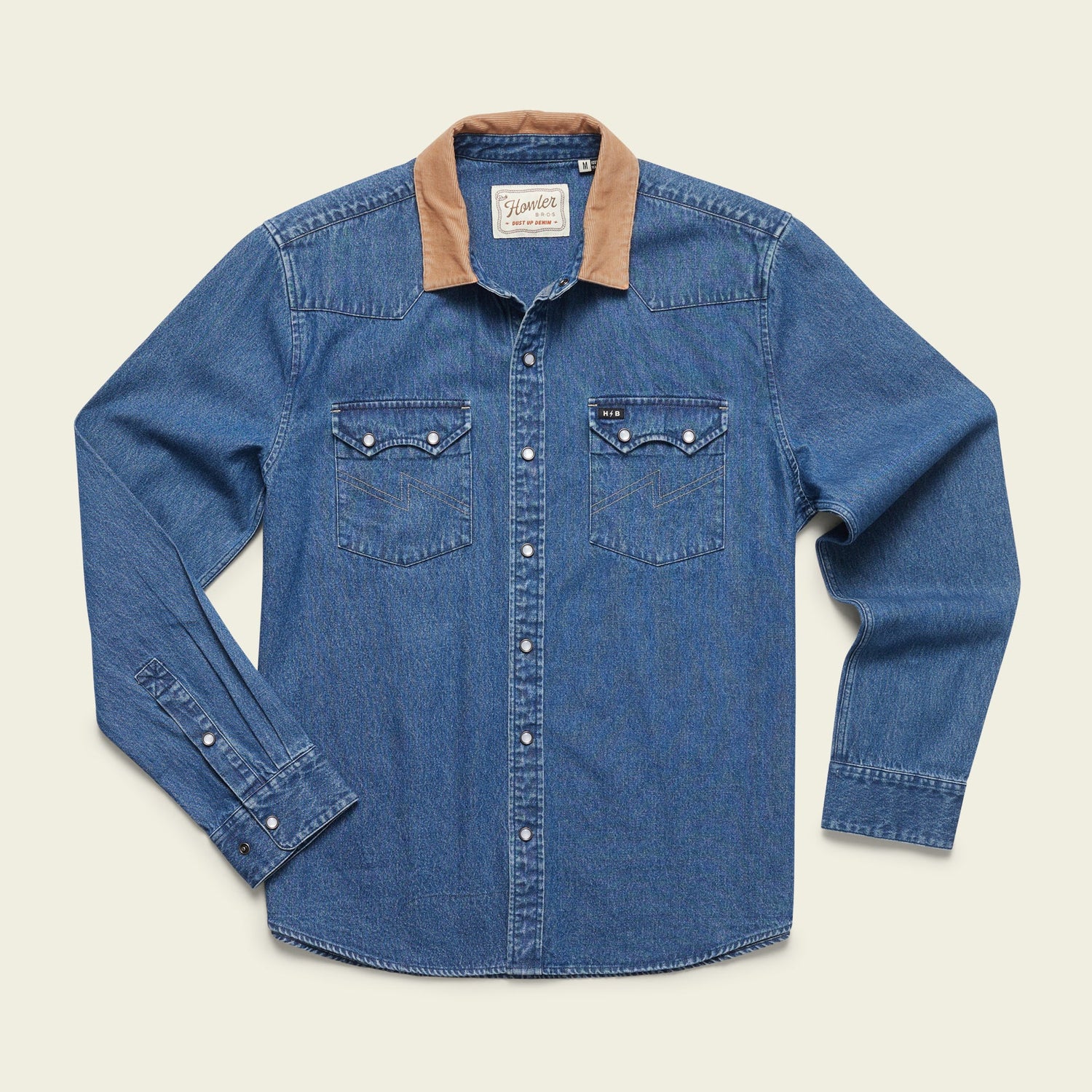 A rugged cotton shirt, this blue denim long-sleeve features a tan corduroy collar, pearl snap buttons, and two front chest pockets, blending versatile style with classic Denim Snapshirts flair. Laid flat on a light background. - View 4