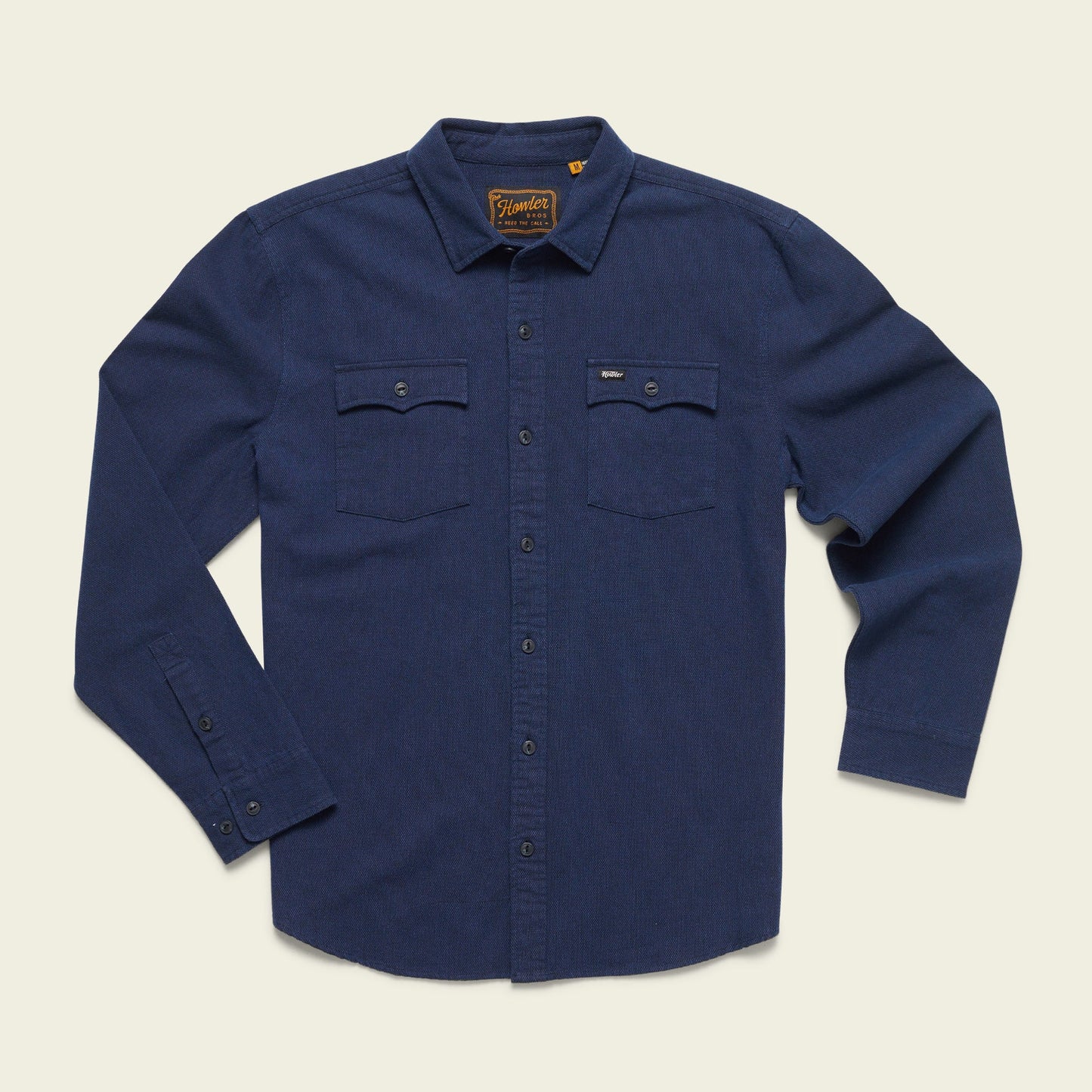 A long-sleeve, button-up navy blue western shirt with two chest pockets and buttoned cuffs, laid flat on a light background. - View 2
