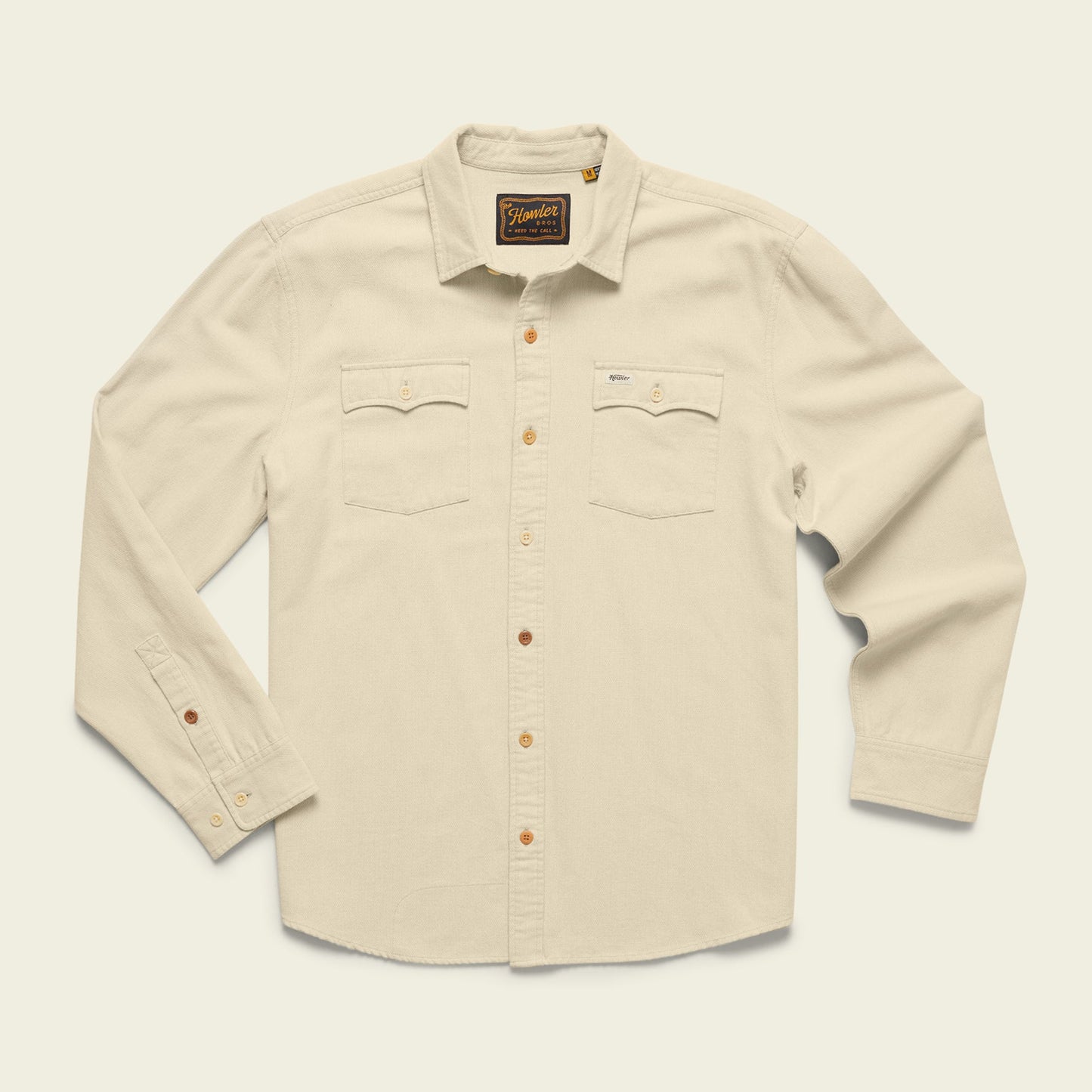 A cream-colored Novato Shirt, this western shirt features long sleeves, two chest pockets, and brown buttons, displayed on a plain light background. - View 1