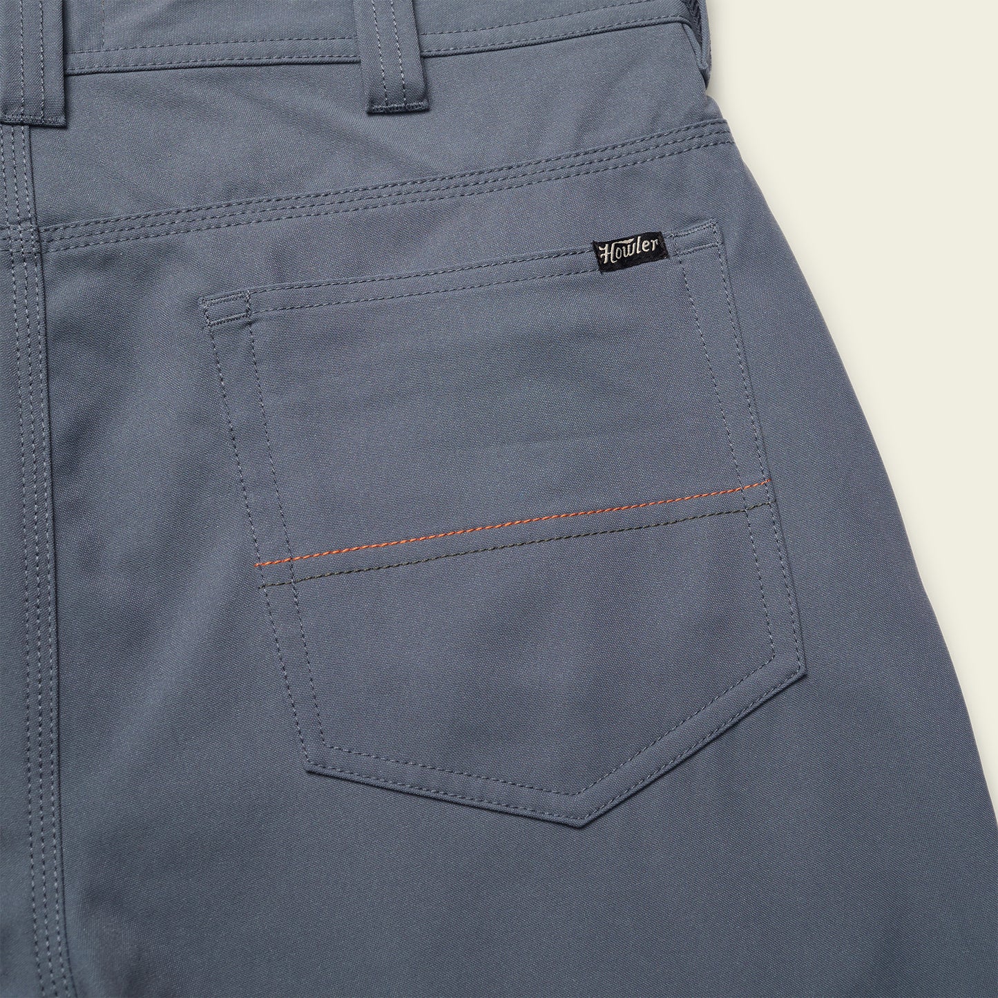 Close-up of the back pocket of gray Frontside Tech Pants with a small black Howler tag above the pocket and a horizontal red stitching detail, combining classic 5-pocket pants style with modern tech fabric performance. - View 3