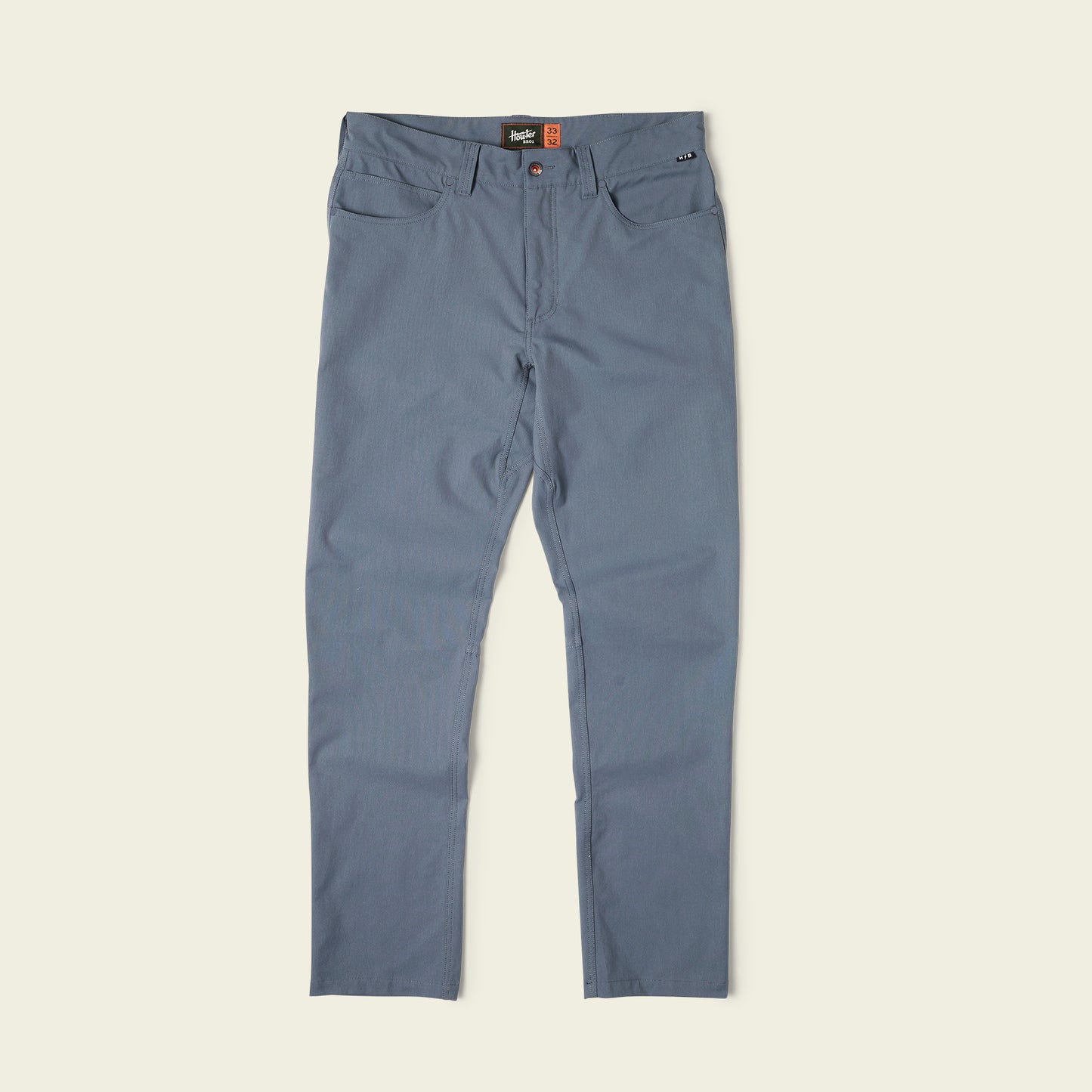 A pair of blue Frontside Tech Pants with slim-fit design, front and back pockets, button and zipper closure, displayed flat on a light background. - View 1