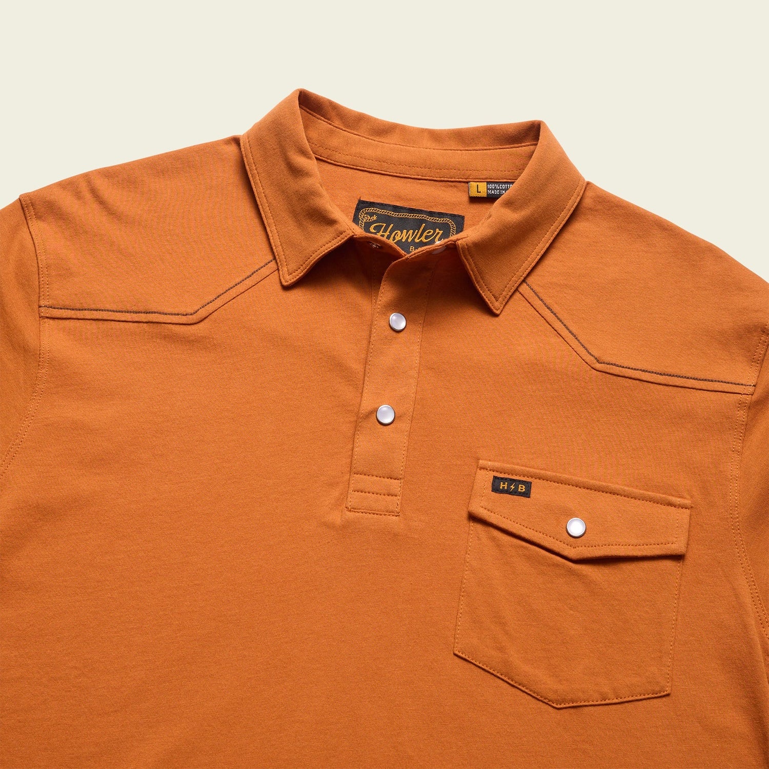 An orange Ranchero Polo crafted from heathered cotton, featuring a button-up placket, front chest pocket, subtle stitching details, and white buttons. The visible Howler brand label inside the collar adds to its western style polo charm. - View 3