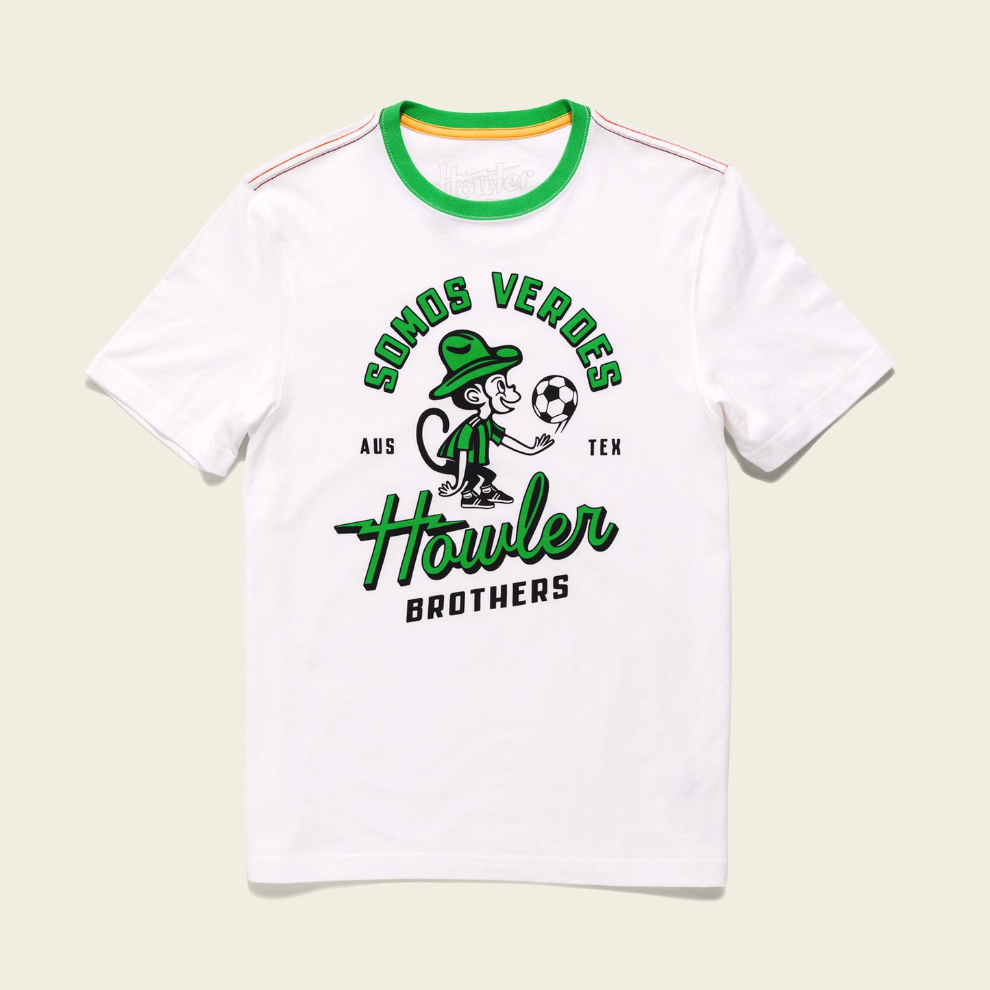 White t-shirt with green accents from the Verde Collection, featuring a cartoon monkey in a green hat holding a soccer ball. Text above reads SOMOS VERDES AUS TEX and below Howler BROTHERS—a nod to Austin FC vintage t-shirts. - View 1