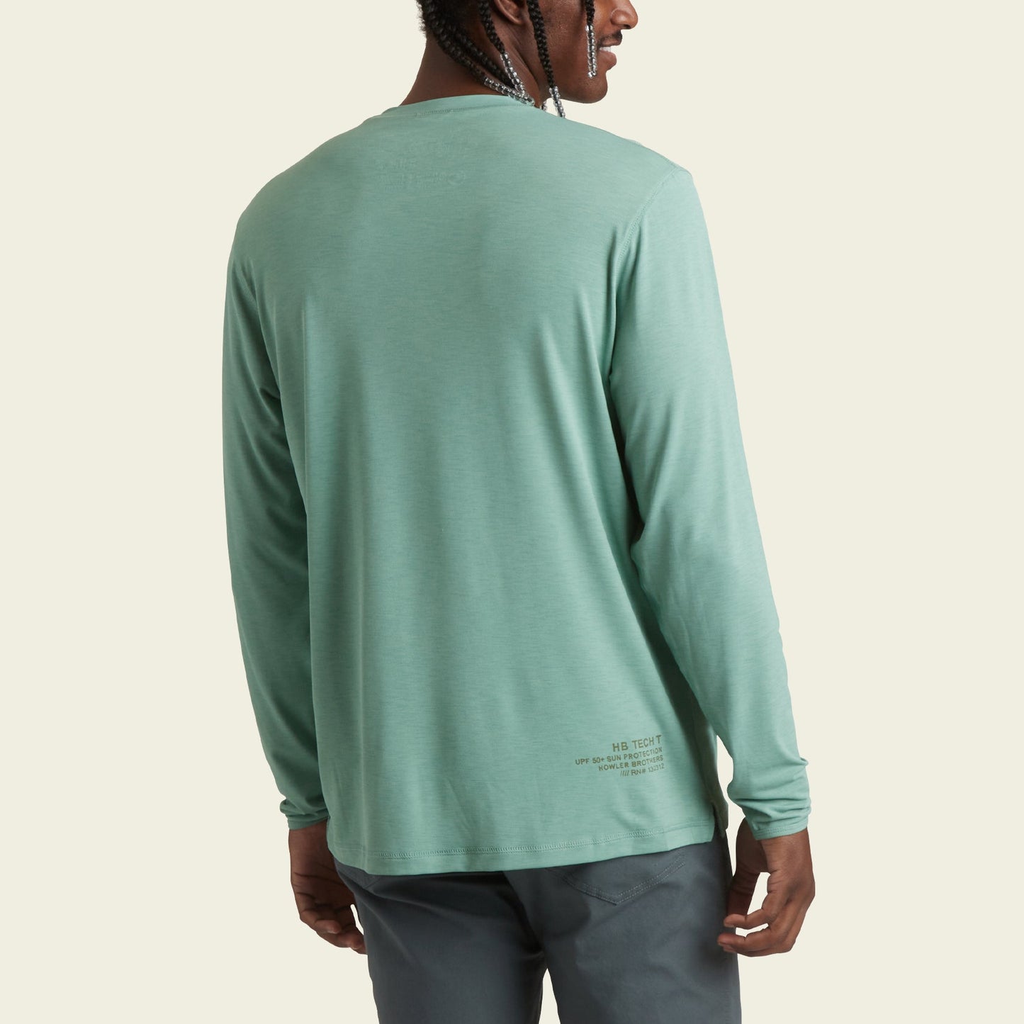 A person is shown from the back, wearing a light green, long-sleeve lightweight cover up and dark gray pants. The plain, light-colored background highlights their braids—perfect protection with UPF 50+ for outdoor activities. - View 4