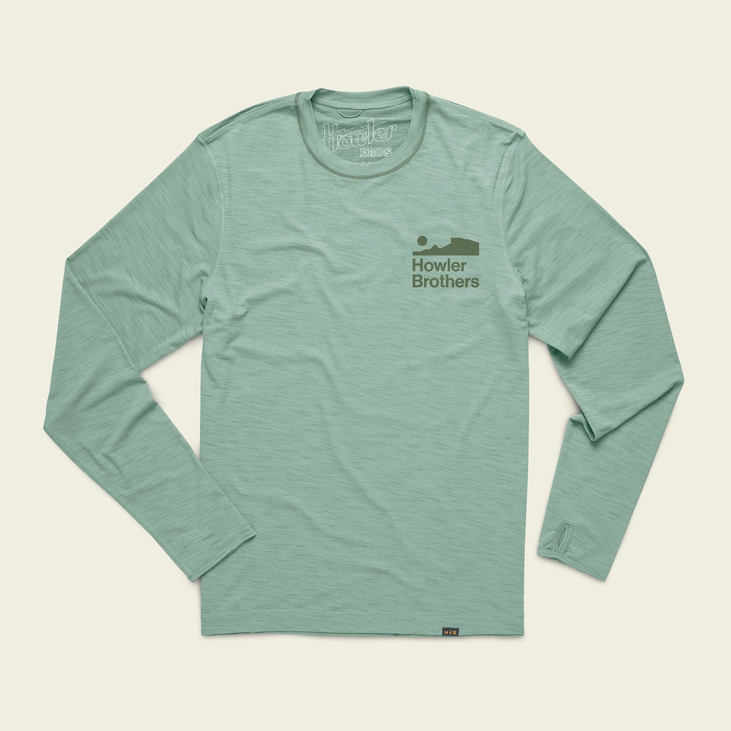 Light green long-sleeve shirt with Howler Brothers and a simple fish graphic in darker green on the left chest. This lightweight cover up is perfect for outdoor activities and offers UPF 50+ protection. Laid flat on a cream background. - View 1