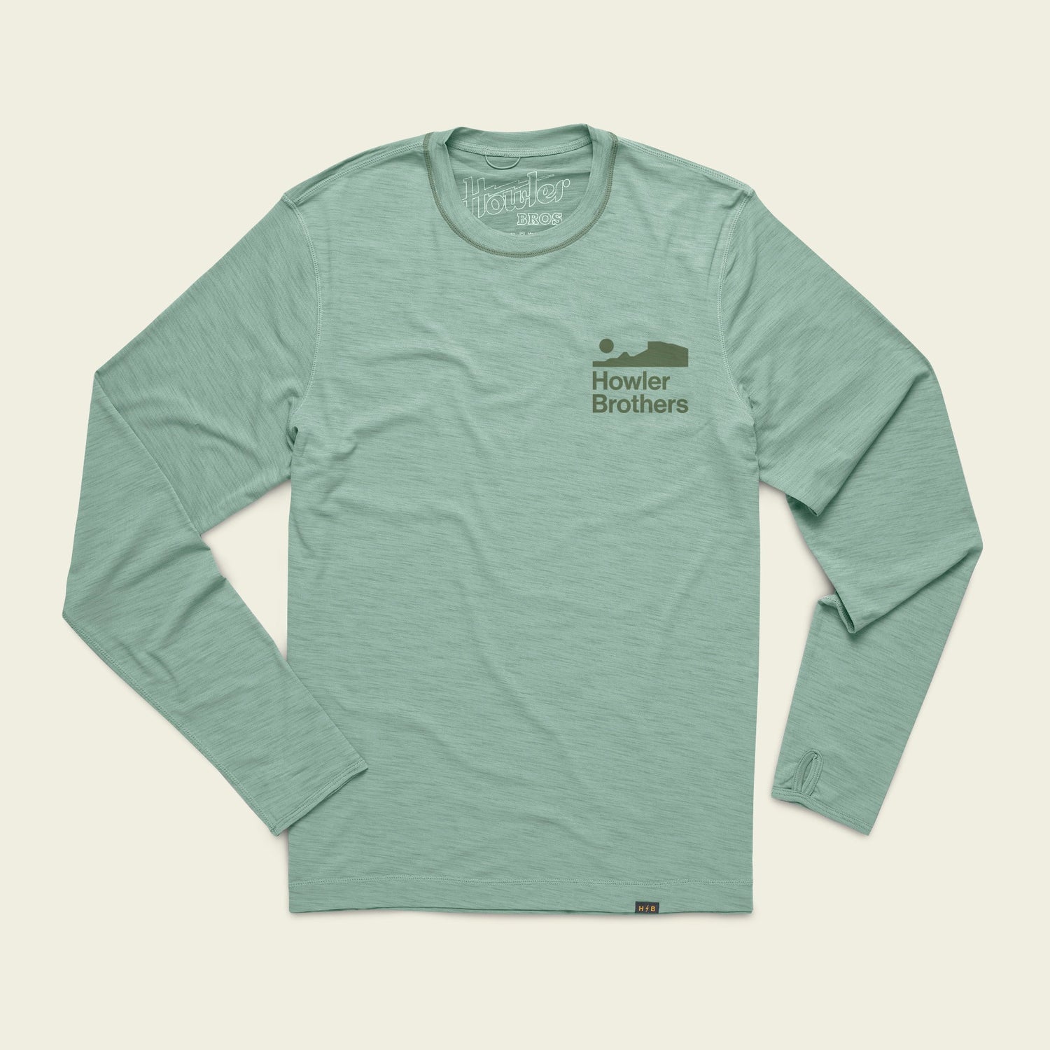 Light green long-sleeve shirt with Howler Brothers and a simple fish graphic in darker green on the left chest. This lightweight cover up is perfect for outdoor activities and offers UPF 50+ protection. Laid flat on a cream background.
