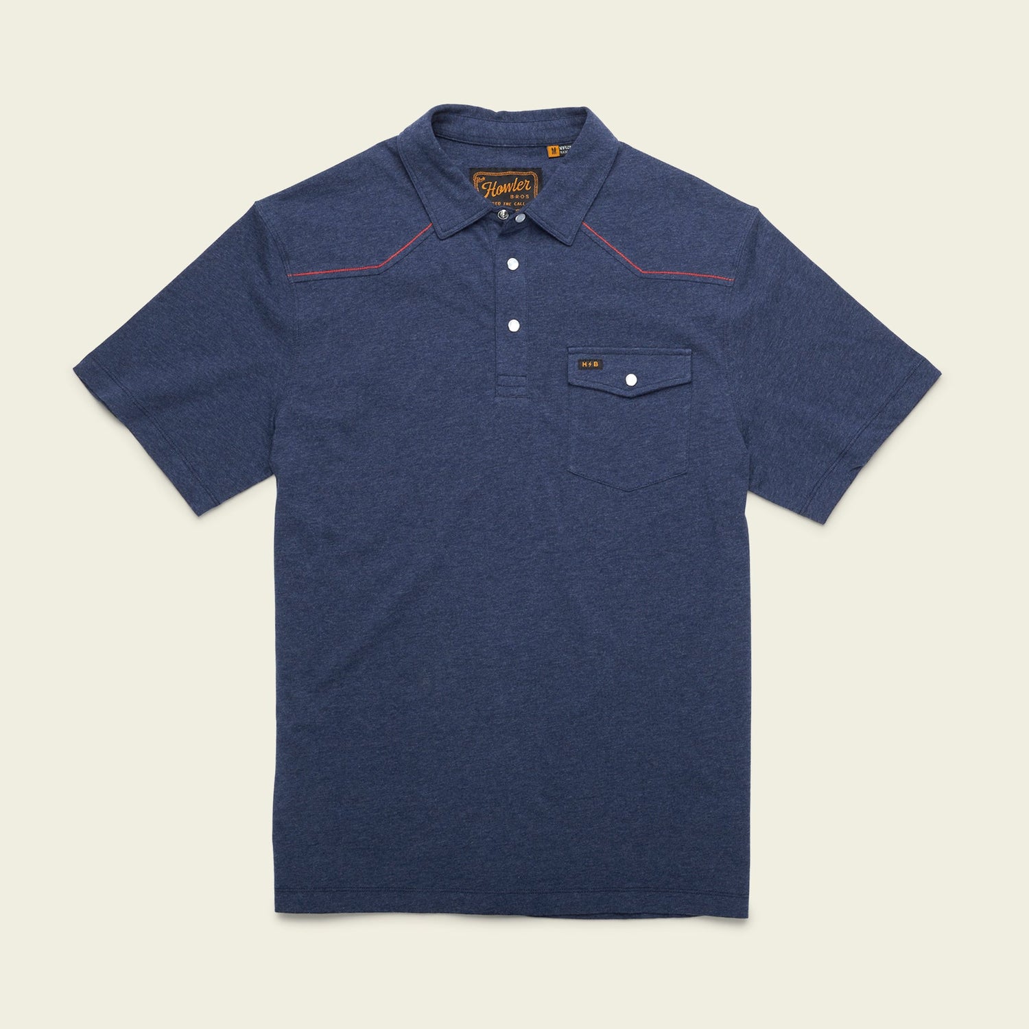 A short-sleeve navy blue Ranchero Polo shirt made from 100% cotton, featuring a button-up collar, front chest pocket with button flap, western yokes, and red stitching detail on the shoulders, laid flat on a light background. - View 20