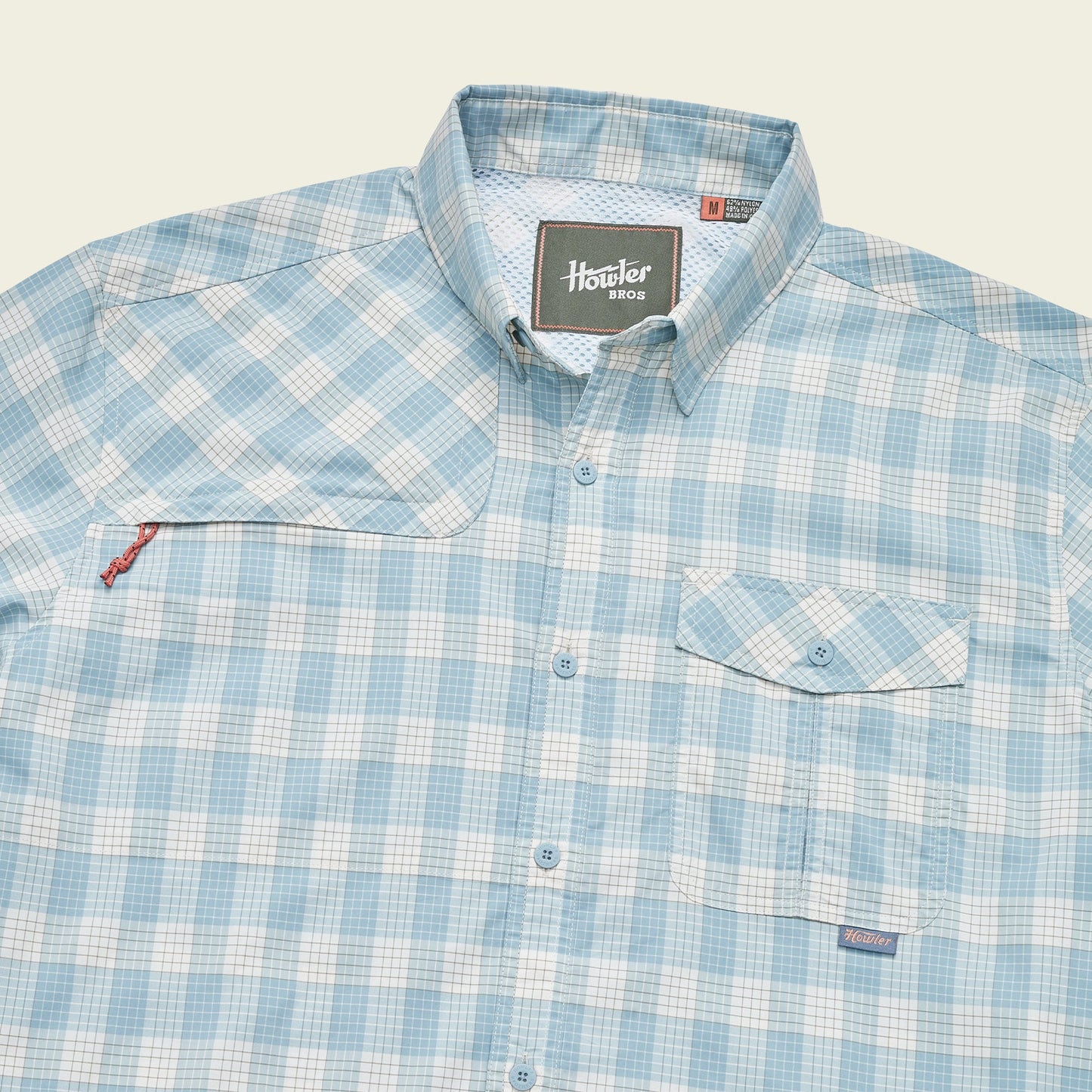 A light blue and white plaid Matagorda Shirt with a collar, front chest pocket with flap, quick drying fabric, and a Howler Bros label on the inside neck and above the pocket—perfect as your travel shirt. - View 6