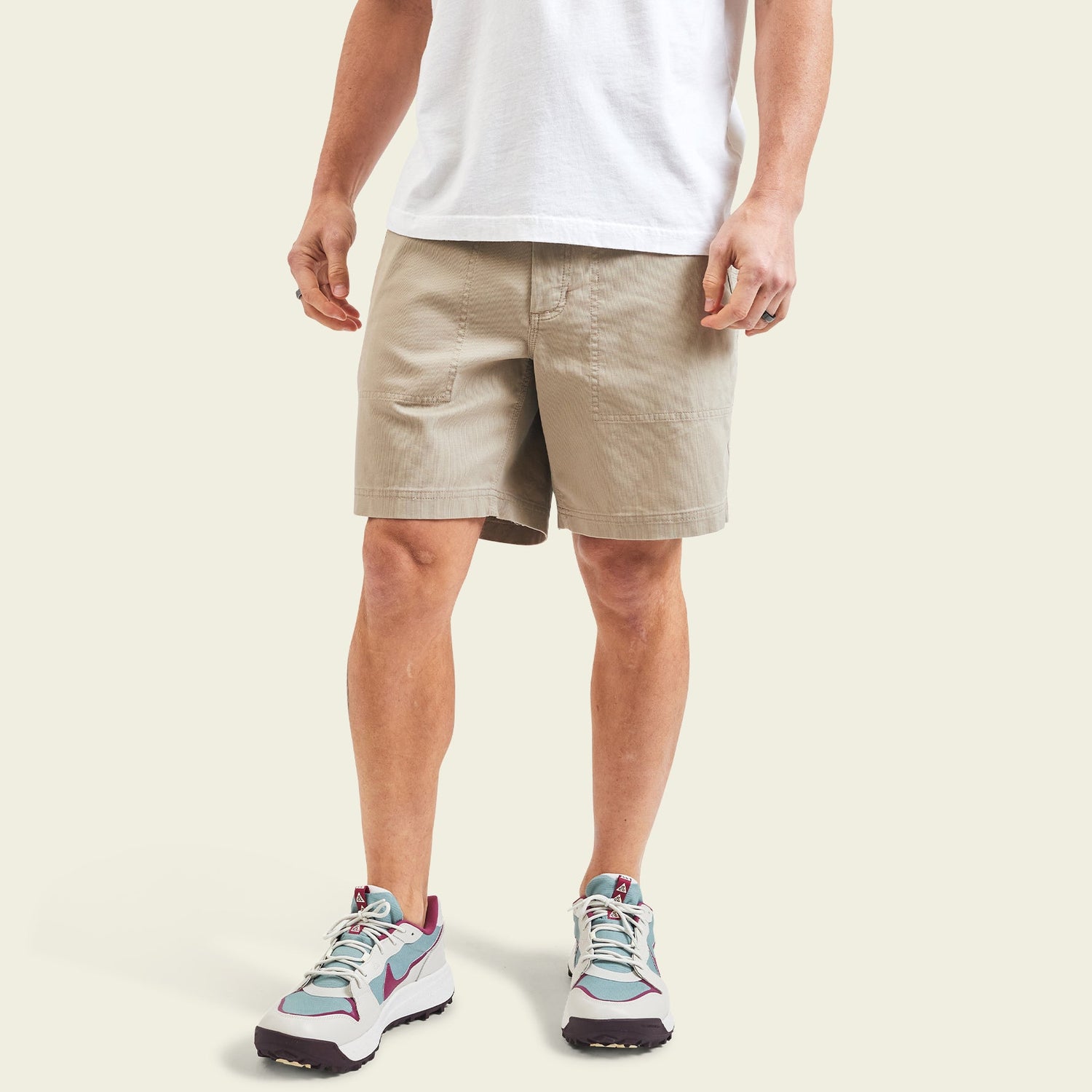 A person wearing a white t-shirt and cotton twill shorts with a hidden snap pocket, paired with white sneakers featuring teal and maroon accents, stands against a plain light background. Only the lower half of the body is visible. - View 4