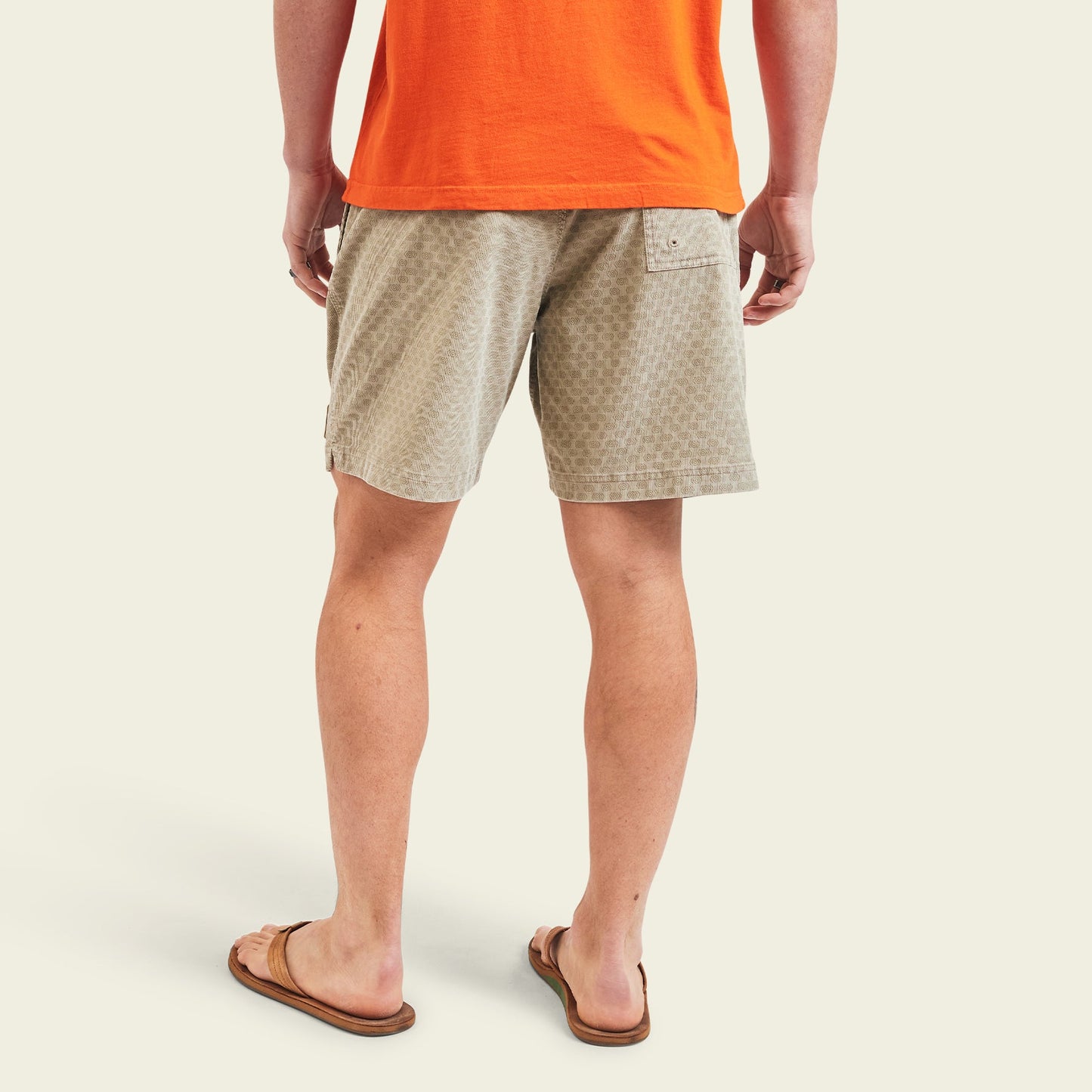 A person stands facing away, wearing an orange t-shirt and Pressure Drop Cord Shorts made from stretch cotton corduroy with an elastic waistband, plus brown flip-flops, all set against a light background. - View 5