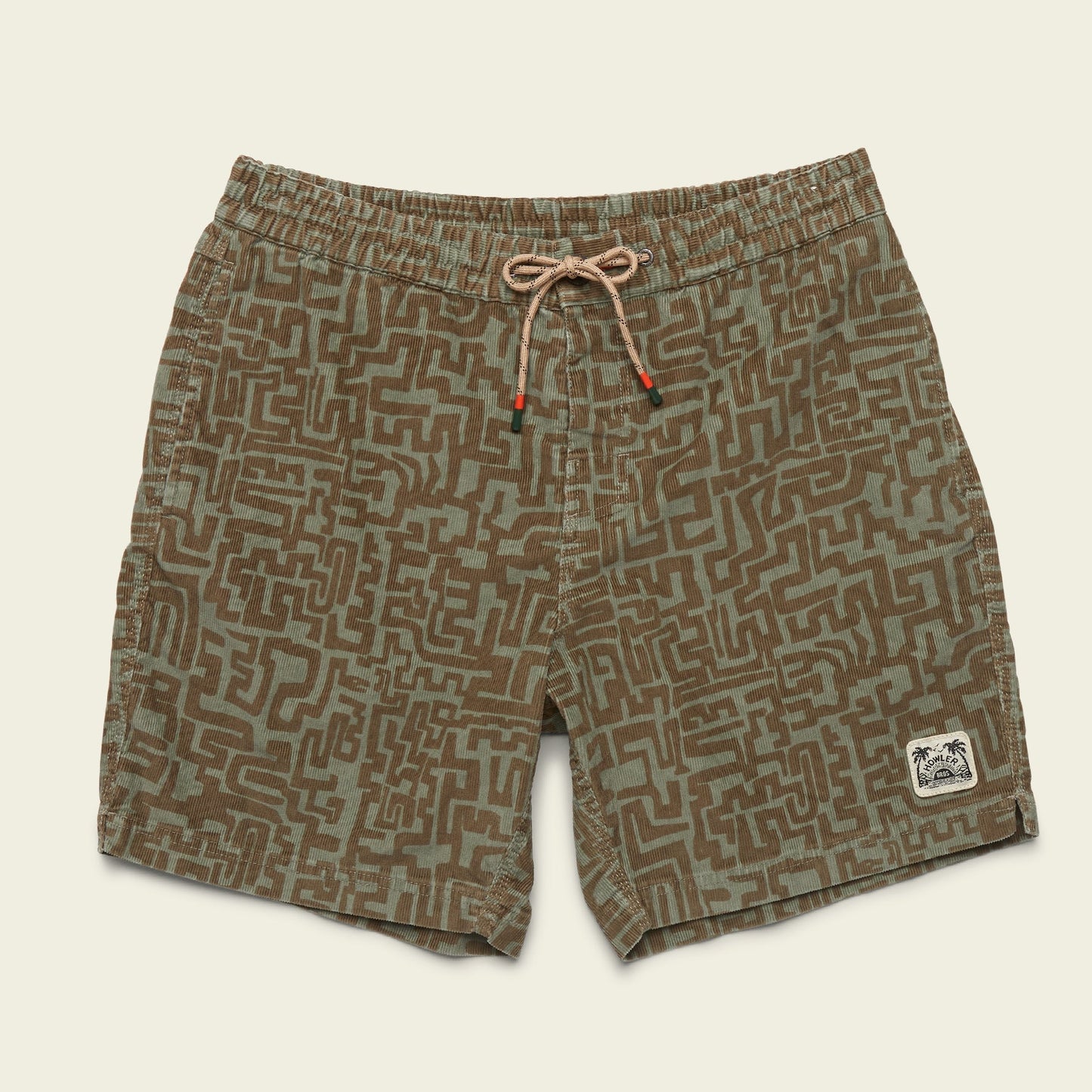 Green and brown patterned Pressure Drop Cord Shorts, crafted from stretch cotton corduroy for all day comfort. Features an elastic waistband, tan drawstring, and a small patch graphic on the bottom left leg, laid flat on a light background. - View 7