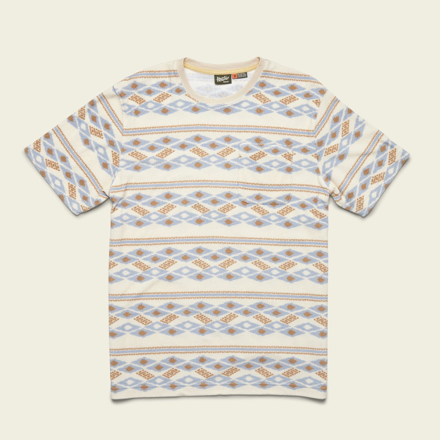 Short-sleeve T-shirt with a crew neck and an all-over geometric pattern in beige, blue, and brown tones arranged in horizontal rows. Inspired by vintage surfing t-shirts and made from comfortable terrycloth, it’s laid flat on a light background. - View 2