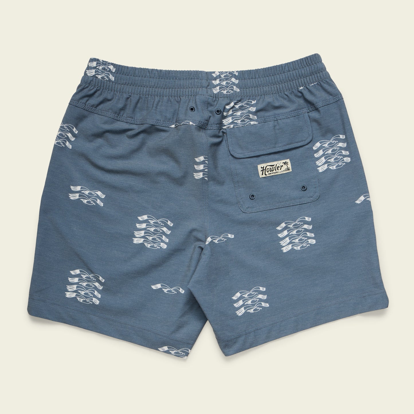 Blue boardshorts with a white abstract wave pattern, elastic waistband, 7” inseam, side pocket, and a back pocket with a Hawker label patch. The shorts are laid flat on a light background. - View 8