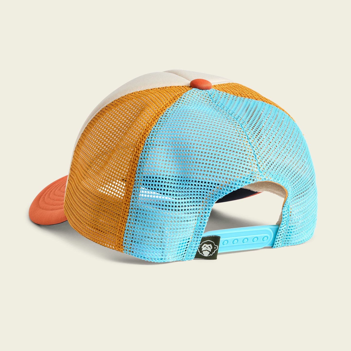 A colorful, vintage-inspired hat shown from the back, featuring orange and blue mesh panels, a light blue adjustable snap closure, and a small black tag above it. The high crown hat has a red brim and a white foam front panel. - View 4