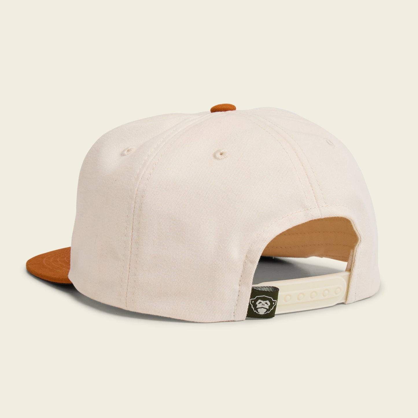A cream-colored unstructured snapback cap with a brown brim, shown from the back. The adjustable white strap and a small black tag with a white bear logo are visible—a laid-back nod to Los Longhorns de Tejas style. - View 3
