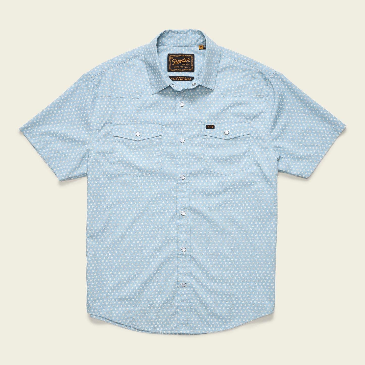 Light blue H Bar B Snapshirt with short sleeves, subtle white polka dot pattern, pearl snap buttons, two chest pockets with button flaps, and a small black logo tag above the left pocket. Shirt is laid flat on a plain background. - View 18