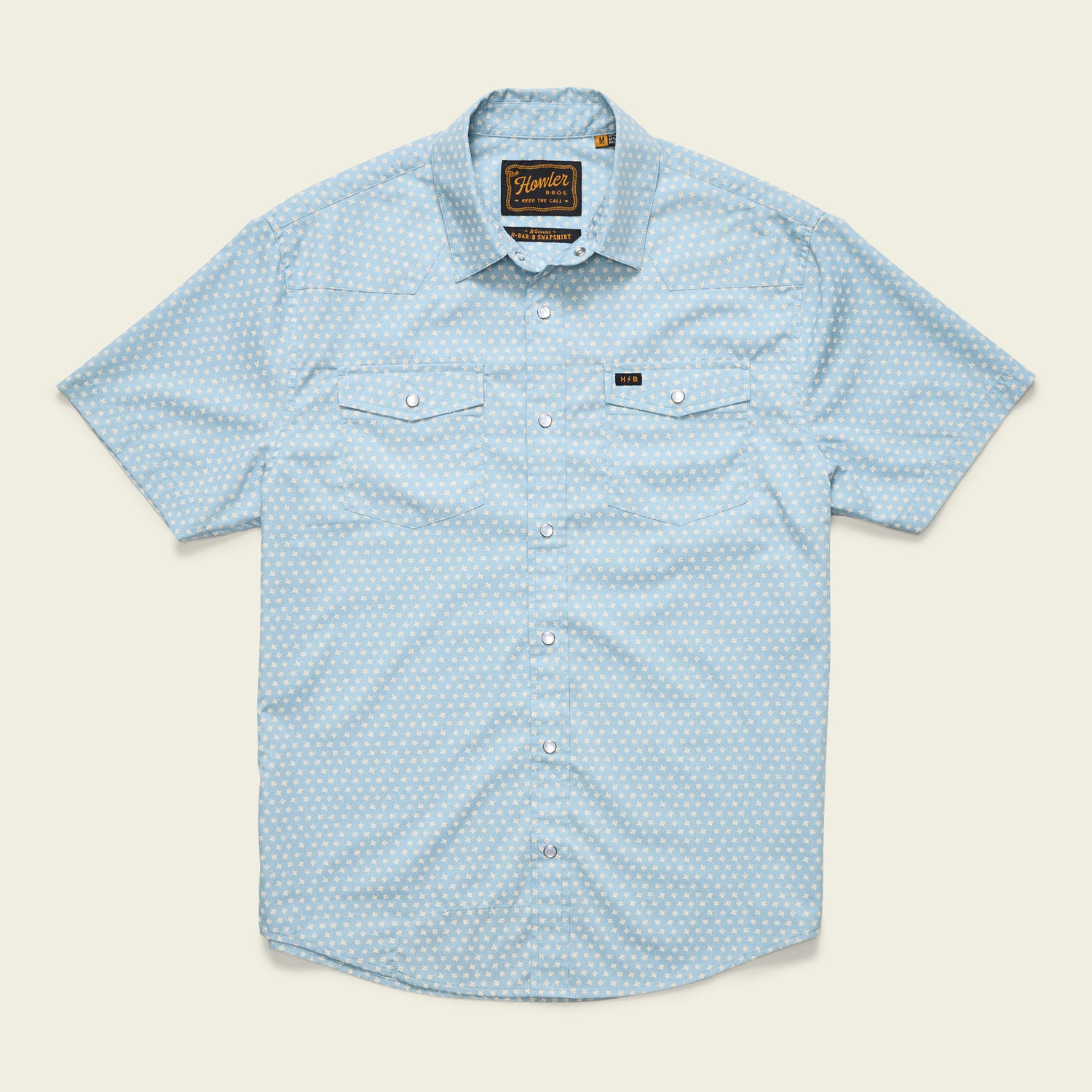 Light blue H Bar B Snapshirt with short sleeves, subtle white polka dot pattern, pearl snap buttons, two chest pockets with button flaps, and a small black logo tag above the left pocket. Shirt is laid flat on a plain background. - View 18