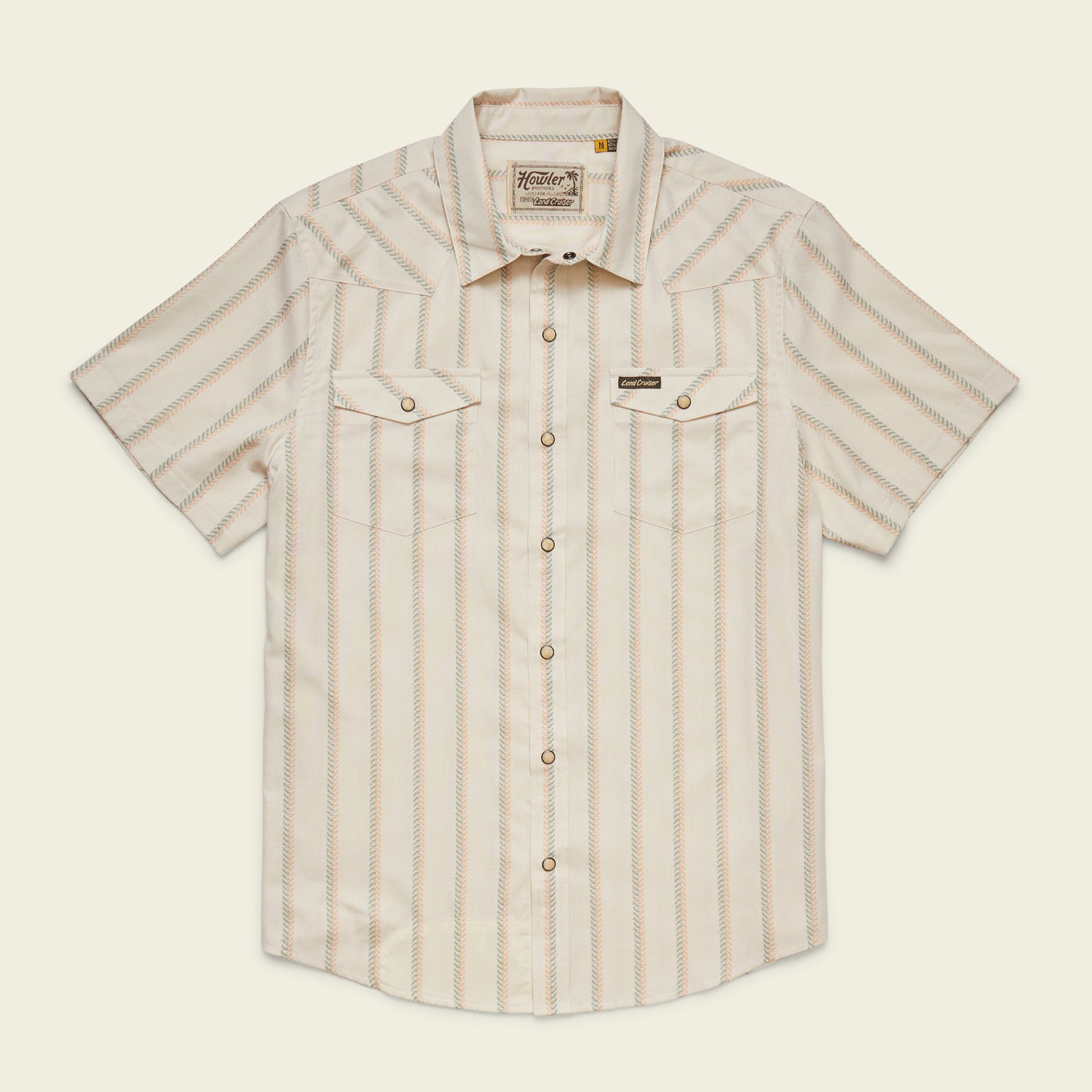 A vintage inspired shirt, this short-sleeve, button-up Howler Brothers features light beige and tan vertical stripes, chest pockets with flaps, pearl snaps, and a pointed collar, laid flat on a neutral background. - View 1