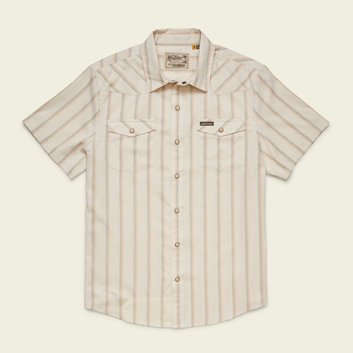 A vintage inspired shirt, this short-sleeve, button-up Howler Brothers features light beige and tan vertical stripes, chest pockets with flaps, pearl snaps, and a pointed collar, laid flat on a neutral background. - View 1