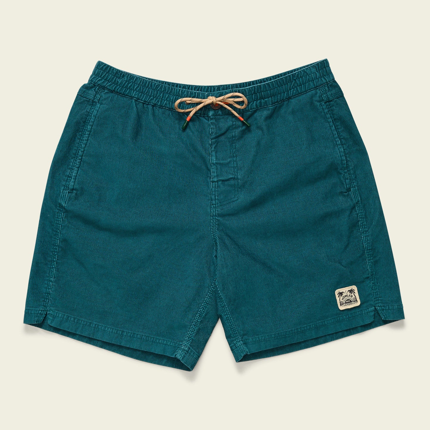 Teal Pressure Drop Cord Shorts with an elastic waistband, beige drawstring, side pockets, and a small stitched palm tree patch on the lower left leg. These comfortable shorts are displayed flat on a neutral background. - View 1