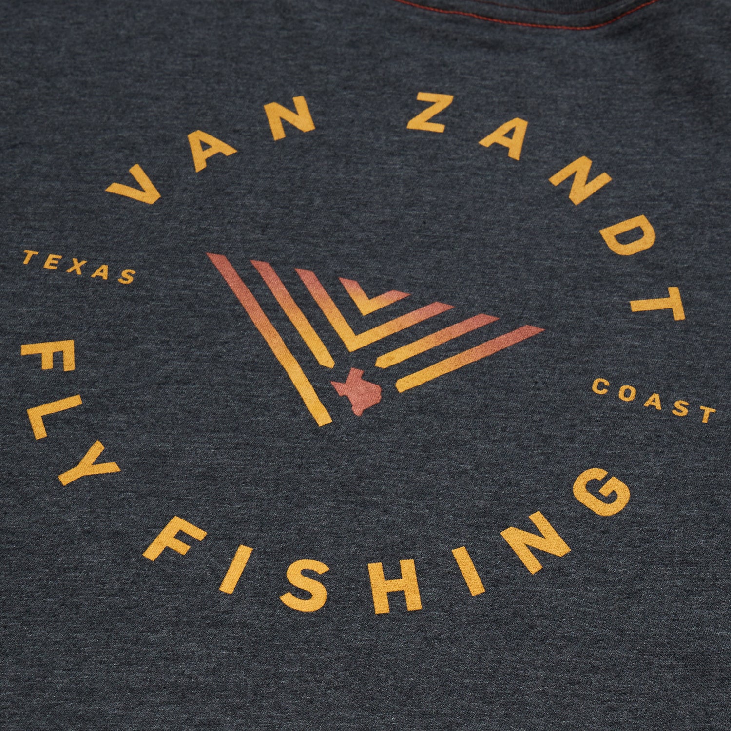 Dark gray shirt from the JT Van Zandt Collection featuring a circular logo that reads VAN ZANDT FLY FISHING in yellow-orange text, with TEXAS and COAST on either side—a tribute to the Texas coast. Part of the Howler Select T-Shirts series. - View 4