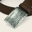 A close-up of a brown leather belt from Cityboy Forge, featuring a custom coordinates buckle—a rectangular, textured silver design engraved with 41°5328N 87°4432W.