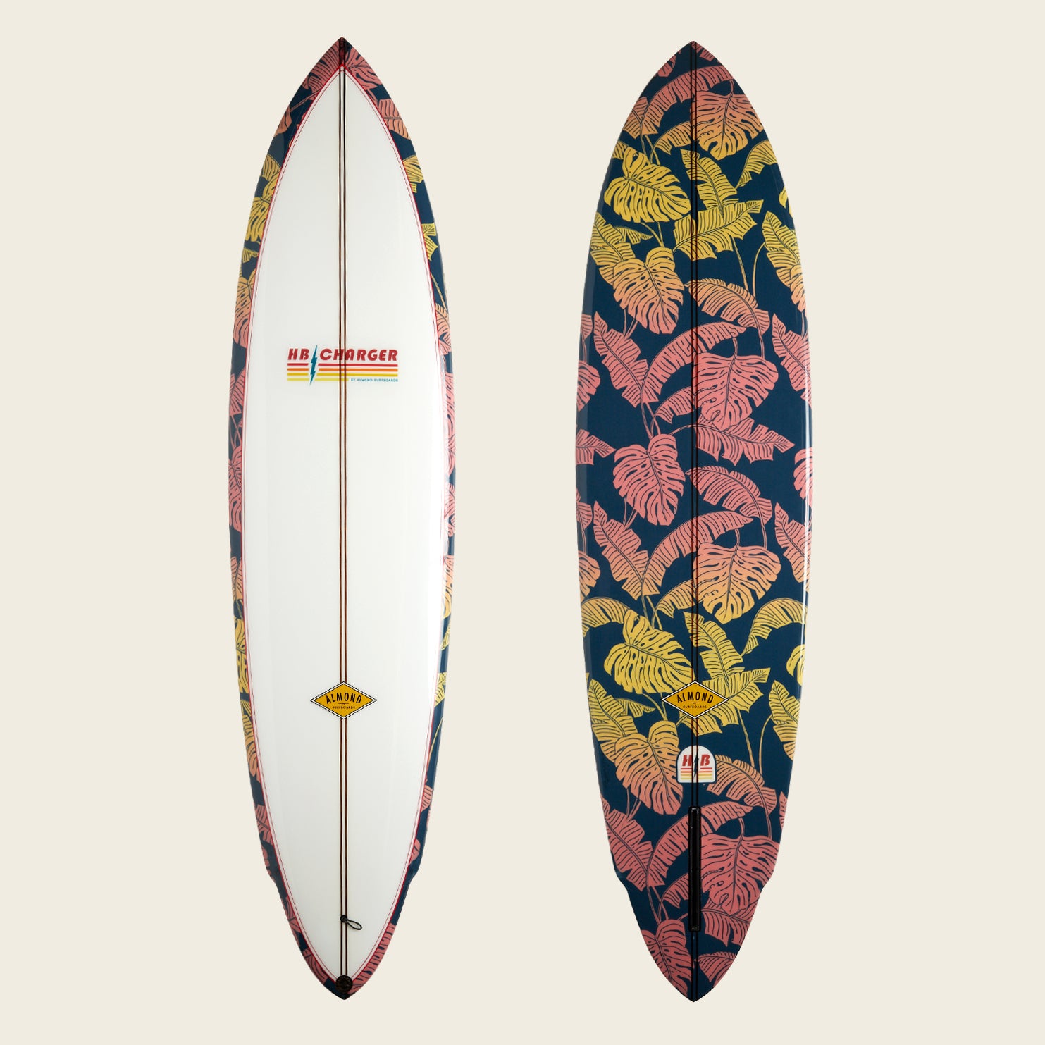 Two surfboards side by side: the left is mostly white with patterned edges and an HB Charger surfboard logo, while the right showcases a bold tropical leaf print in pink and yellow on a dark background. - View 1