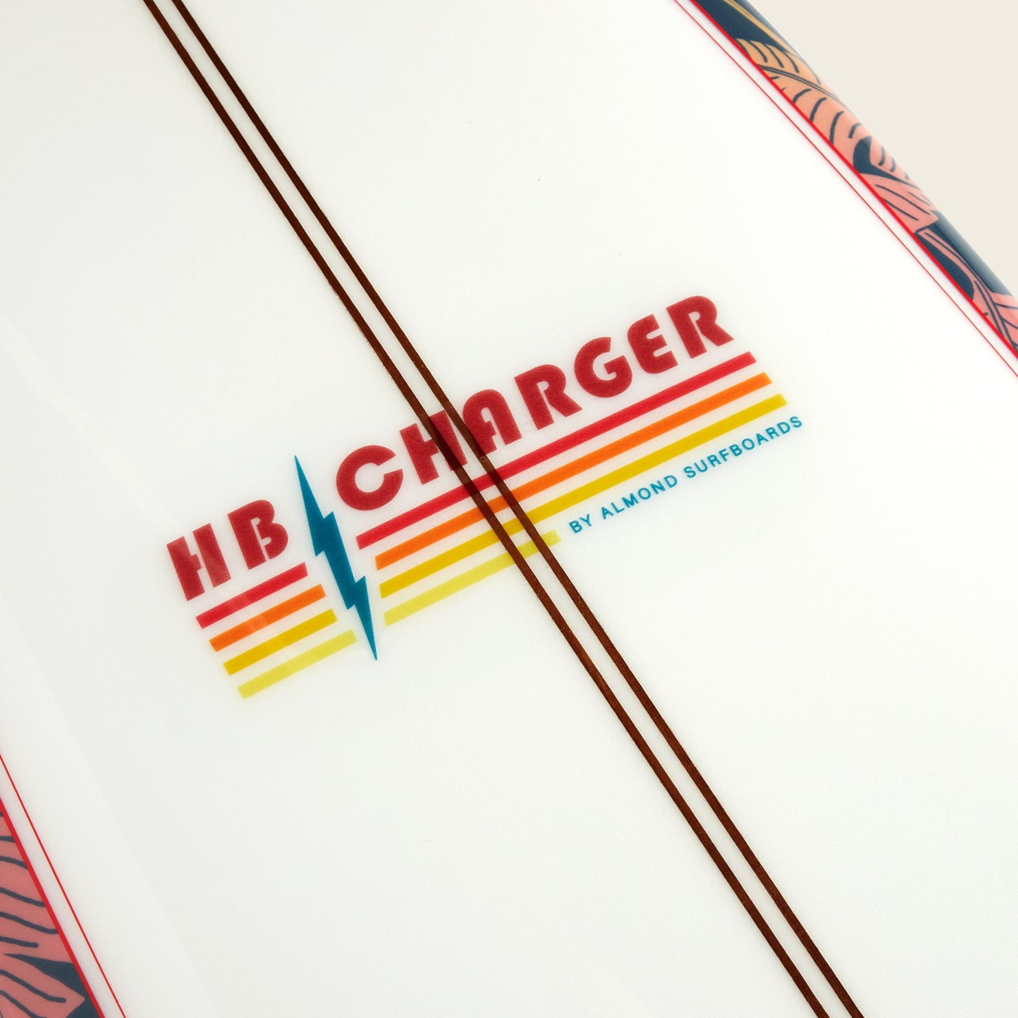 Close-up of an HB Charger surfboard from Almond Surfboards, featuring retro red, yellow, and orange stripes with a blue lightning bolt on white. Two brown lines run alongside the logo from the Howler Shaper Series. - View 4